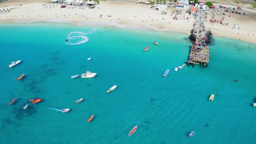 Jet skis, boats and pier in Santa Maria, Sal Island, Cape Verde (Cabo Verde). Drone footage.