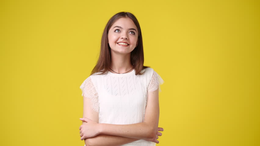 4k video of girl with cunning facial expression on yellow background. | Shutterstock HD Video #1100756247