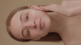 Funny happy attractive young woman applies skin care cream to her face, looks at the camera, applies moisturizing facelift cream, healthy skin care concept. - Powered by Shutterstock - Get 15% off with code: PIKWIZARD15