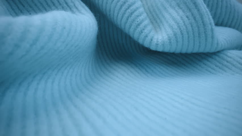 Macro shot wool fabric, knitted wool pullover. Slider dolly extreme close-up clothing material blue woollens, wool fibers. Laowa lens camera glides over warm winter clothing fabric texture Royalty-Free Stock Footage #1100759249