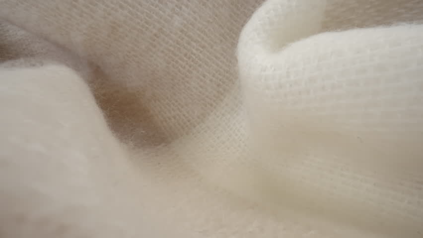 Macro shot of wool fabric plaid, scarf or sweater. Slider dolly close-up wool textile beige color texture. Laowa probe lens camera glides over detailed knit material Royalty-Free Stock Footage #1100759267