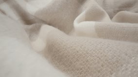 Macro shot of wool fabric plaid, scarf or sweater. Slider dolly close-up wool textile beige color texture. Laowa probe lens camera glides over detailed knit material - Powered by Shutterstock - Get 15% off with code: PIKWIZARD15