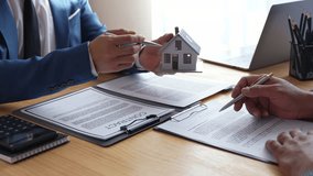 Real estate brokerage agent Hand over the house to the customer and sign the contract agreement home insurance concept Making lease and buying a house - Powered by Shutterstock - Get 15% off with code: PIKWIZARD15