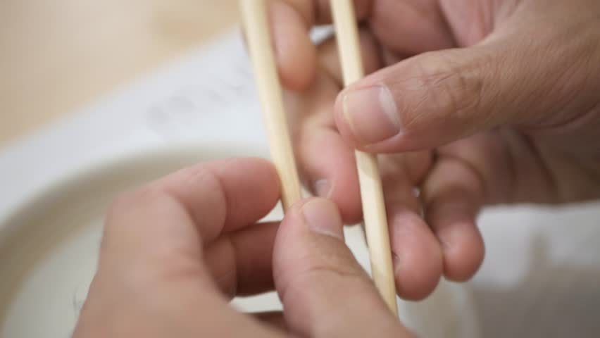 Selective focusing view to hand while prepare chopsticks to eat japanese food | Shutterstock HD Video #1100763129