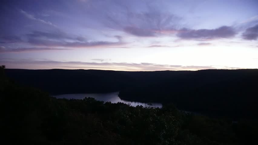 The moon rising over the mountains in Pennsylvania. The stars are visible, as well as the reflection in the water of the Allegheny reservoir below.