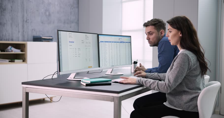 Male And Female Auditors Working On Computer With Invoice At Workplace Royalty-Free Stock Footage #1100767345