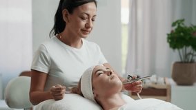 Video of beautiful woman getting oxygen face therapy in a beauty salon. Professional skin care treatment.