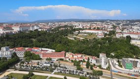 A camera drone flies across Mondego River in Coimbra; the University of Coimbra campus is straight ahead, the Coimbra Military Health Center is on upper right