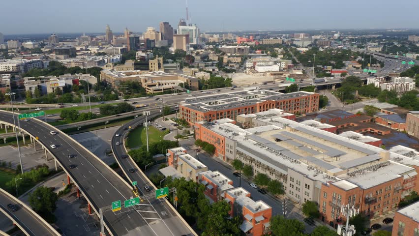 San Antonio Pearl District aerial view of downtown city skyline in the morning, pan right over freeway commuters and apartment complex near riverwalk in 4k