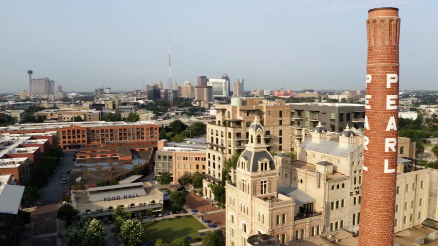 San Antonio Pearl District aerial orbit of brick pearl tower, pan right showing historic warehouse district buildings in 4k