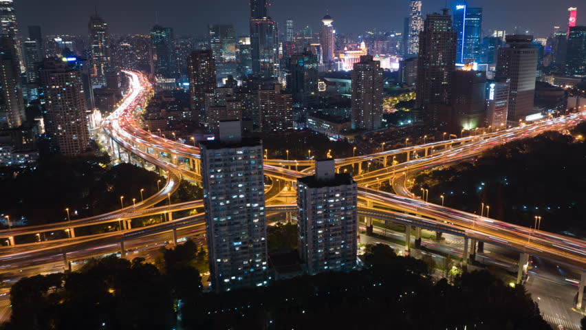 Hyper lapse Rising Drone Shot View Reveals Spectacular Elevated Highway and Convergence of Roads, Bridges, Viaducts in Shanghai Night, Transportation and Infrastructure Development in China Timelapse. Royalty-Free Stock Footage #1100776413
