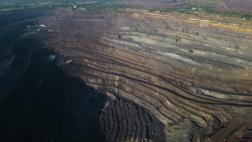 Panorama aerial view shot open pit mine coal mining, dumpers, quarrying extractive industry stripping work. Big Yellow Mining Trucks. View from drone at opencast mining with lots of machinery trucks