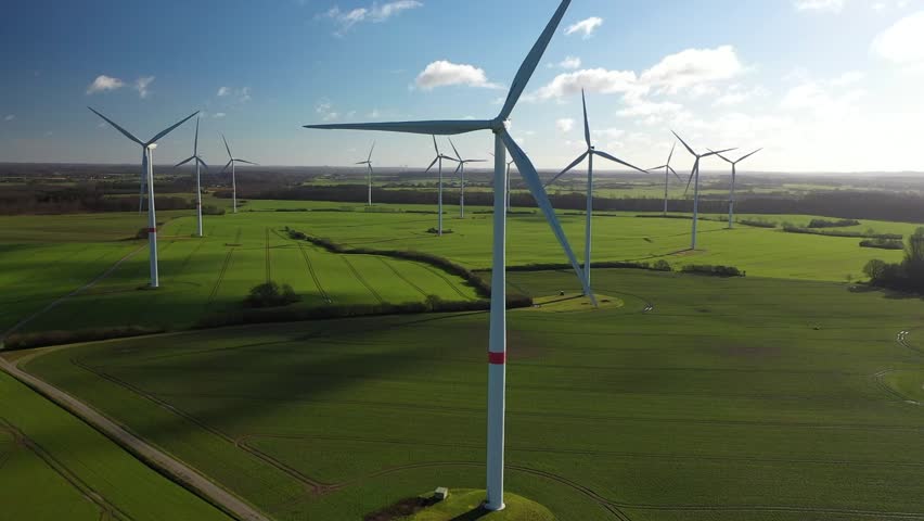 Aerial flying over renewable energy wind farm. Landscape with wind turbines in countryside. Agricultural fields on eco farm modern electric station renewable energy.  Royalty-Free Stock Footage #1100779055
