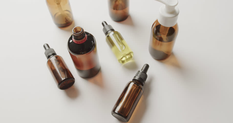 High angle view of glass bottles with copy space on white background. Plastic free beauty and eco packaging concept. | Shutterstock HD Video #1100781001