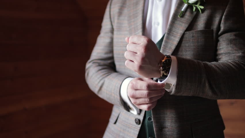 The man adjusts his cufflinks on the sleeves. Groom preparing for a wedding day. | Shutterstock HD Video #1100783105