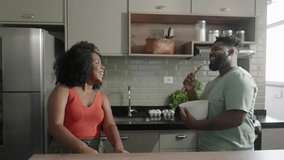 Happy joyful black couple husband and wife having fun singing in the kitchen, cooking together at home. Overjoyed young couple in love preparing meal healthy food, enjoying active family weekend
 - Powered by Shutterstock - Get 15% off with code: PIKWIZARD15
