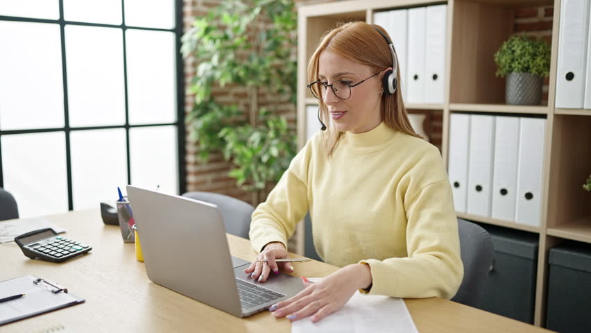 Young blonde woman business worker having video call writing on document at office | Shutterstock HD Video #1100789337