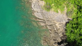 This stock footage captures the stunning beauty of Thailand tropical sea and coastline, surrounded by lush green forests and rugged rock formations, shot from a drone. Perfect for summer travel videos
