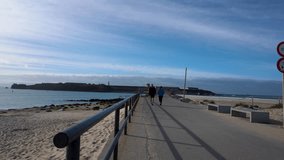 People walking on Isla de Las Palomas Island of Tarifa separating Atlantic Ocean with Mediterranean Sea in Tarifa Spain Europe