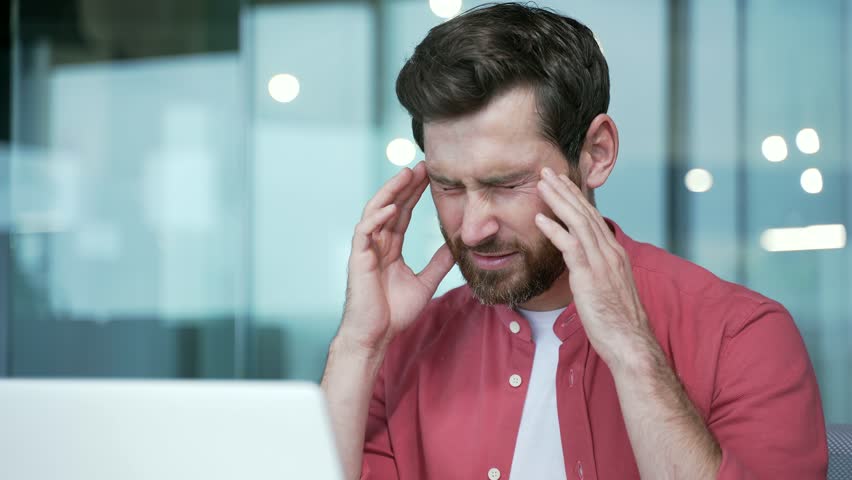 Close up portrait of sad business man freelancer suffering headache painful feelings chronic migraine pressure working on computer at modern office Stressed entrepreneur feels hurt at workplace indoor | Shutterstock HD Video #1100795863