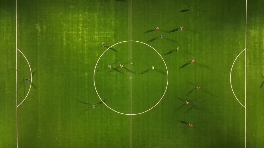 Drone view of athletes playing soccer in a floodlit stadium. Royalty-Free Stock Footage #1100800019