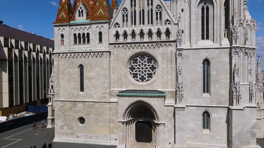 Facade and bell tower of Matthias church. Rising drone shot revealing Budapest panorama