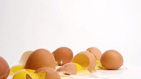 Brown eggs dropped and breaking in slow motion on white studio backdrop in 4k - Powered by Shutterstock - Get 15% off with code: PIKWIZARD15