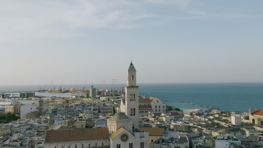 Aerial footage rotating around the the church spire on the Basilica Cattedrale Metropolitana Primaziale San Sabino in Bari, Italy during sunset.