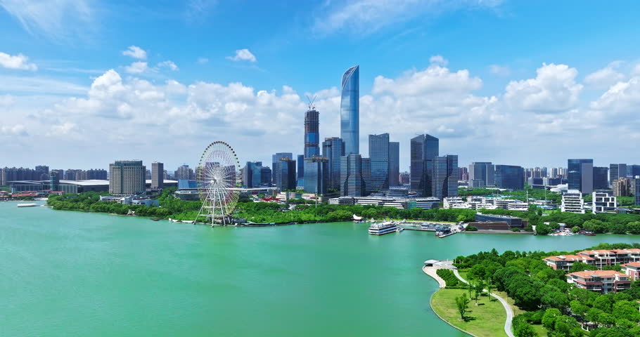 Aerial footage of city skyline and modern buildings with lake scenery in Suzhou, China.