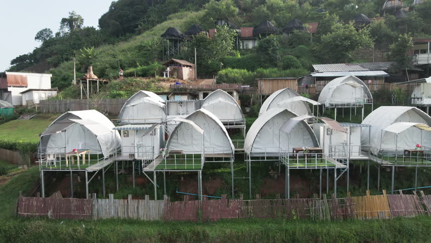 View of modern white accommodation with a terrace on a hillside