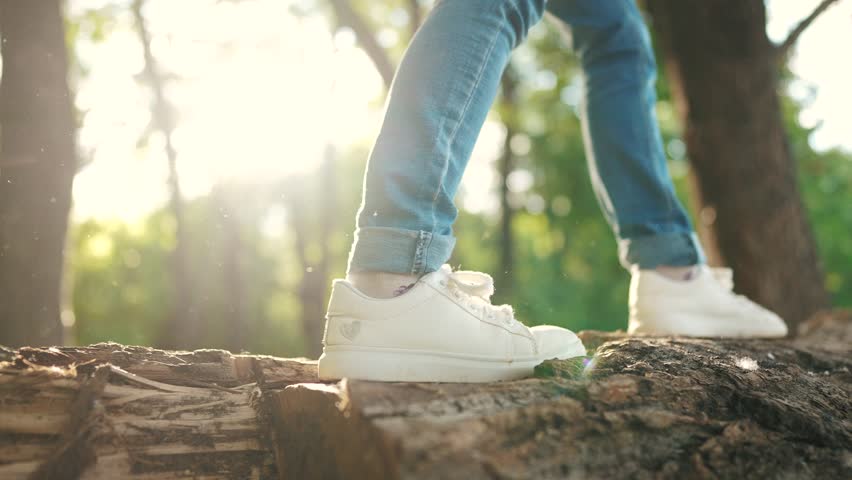 baby girl playing in the forest park. close-up child feet walking on a fallen tree log. happy family kid dream concept lifestyle. a child in sneakers walks on a fallen tree in park Royalty-Free Stock Footage #1100817333