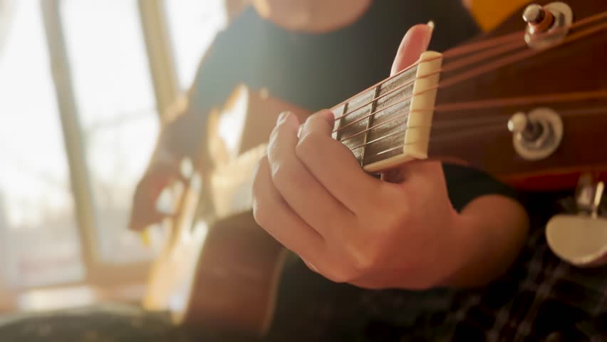 Classic guitar girl play. musician jazz acoustic a instrument concept. guitarist country girl hands close-up plays at the window indoors. learning to lifestyle play the guitar