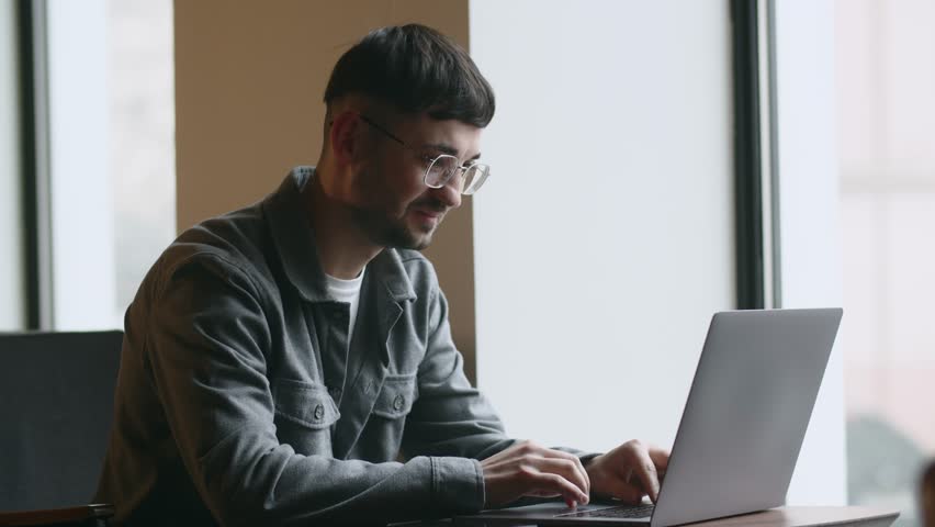 Excited man with laptop expressing happiness and showing yes gesture. Freelancer in glasses is happy about job offer. Remote worker completed task successfully. Work opportunity, career growth | Shutterstock HD Video #1100821667