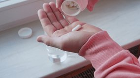 The concept of health, a man drinks a pill with drinking water. Pour the pill from the jar into your hand. Antibiotic capsule - Powered by Shutterstock - Get 15% off with code: PIKWIZARD15