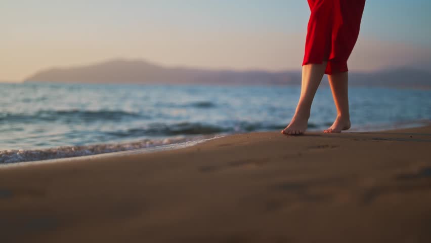 Woman in red dress walks along the beach. | Shutterstock HD Video #1100825481