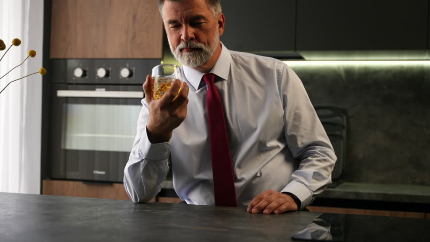 Portrait thoughtful senior man drinking whiskey in luxury interior