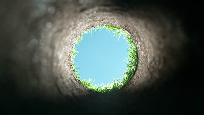 Super slow motion of golf ball falls into the hole at the camera, view inside the hole close-up. Filmed on high speed cinematic camera at 1000 fps. Royalty-Free Stock Footage #1100834619