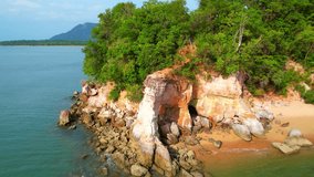 Drone captures serene beauty of sandy beach, green forest, and tropical sea in an enchanting travel concept. (Chamuk Khwai Cape - Tourist attraction in Krabi province, southern Thailand). 4K
