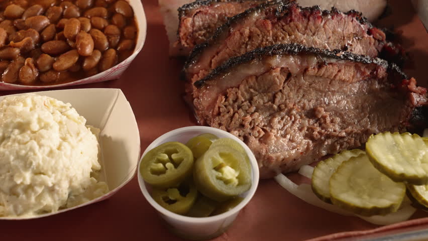 A traditionalTexas barbecue two meat plate with moist brisket and turkey pinto beans potato salad, slider close up 4K