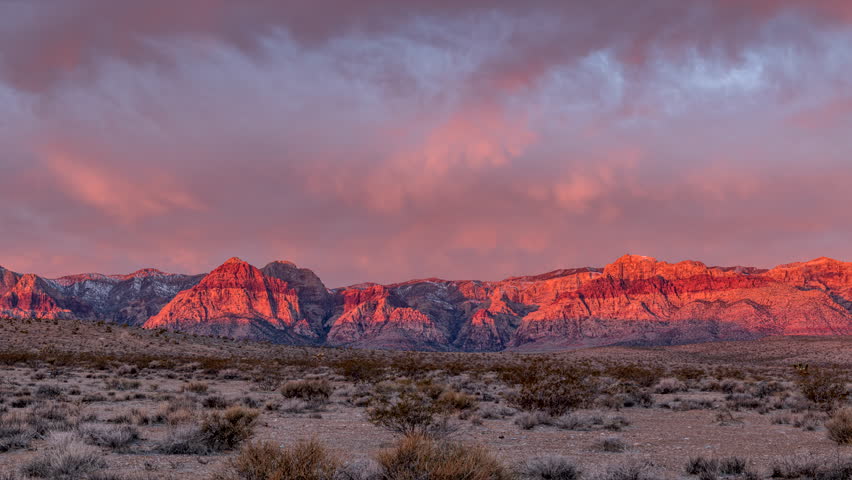 Early morning time lapse at Red Rock Canyon in Las Vegas shows the sun poking through to light up the deep red rocks of this state park Royalty-Free Stock Footage #1100838215