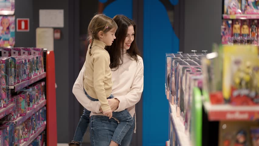 Shopping concept. Mother and daughter are choosing toys on the shelf in the mall Royalty-Free Stock Footage #1100838347