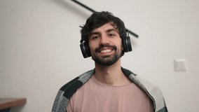 Smiling bearded man with headphones looking to the camera