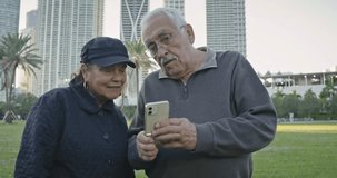 Older couple doing video chat on their cell phone at a park in Florida