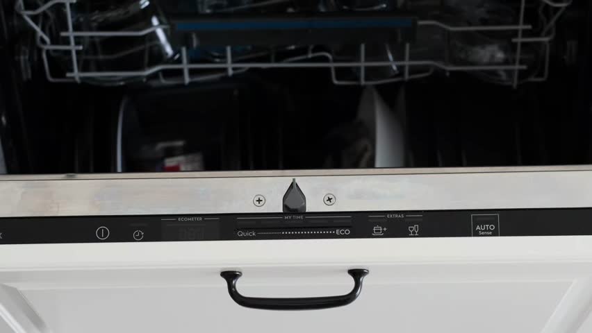 A finger is turning on a built-in dishwasher and selecting eco mode, closing the door.A woman hand is pressing the start button of built-in dishwasher control panel.Modern white kitchen. Close-up	
 | Shutterstock HD Video #1100842465