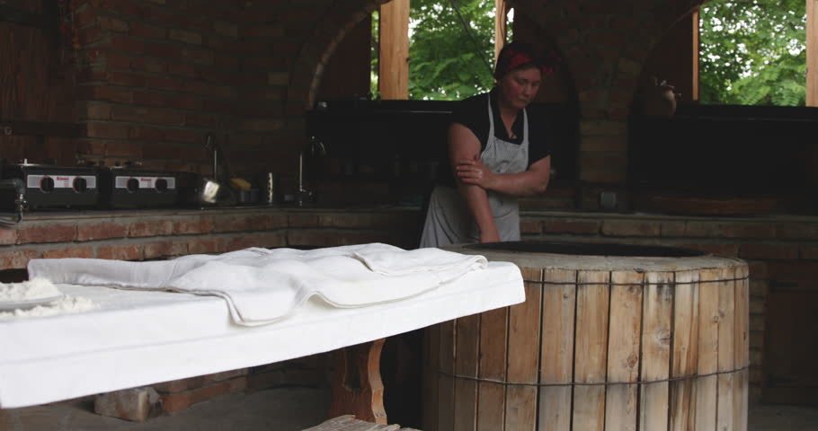 Old Woman Baker Preheating The Traditional Round Clay Oven In Kakheti, Georgia. - Medium Shot, Slow Motion