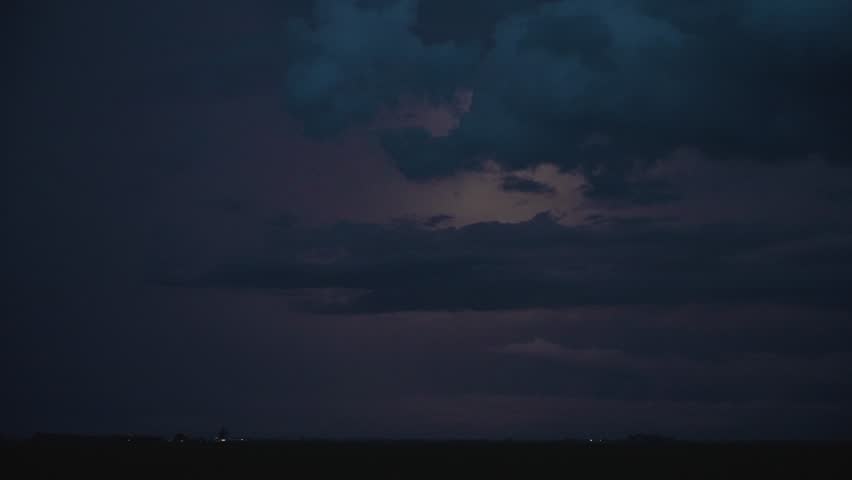 Lightning flickers across the sky as a storm retreats into the night.
