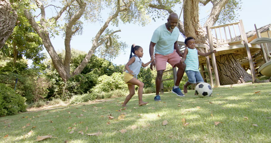 Happy african american grandparents with grandchildren playing football in garden, in slow motion. Spending quality time at home concept. Royalty-Free Stock Footage #1100856037