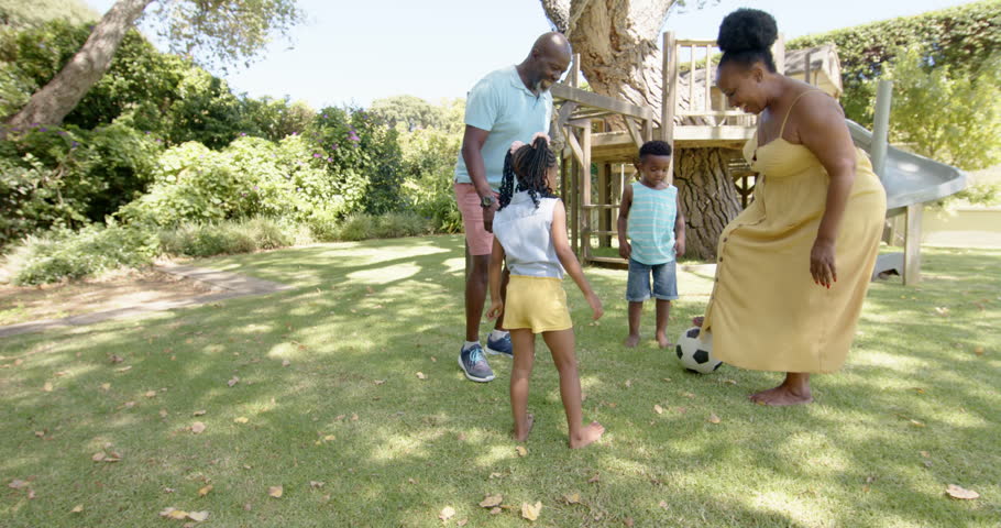 Happy african american grandparents with grandchildren playing football in garden, in slow motion. Spending quality time at home concept. Royalty-Free Stock Footage #1100856147