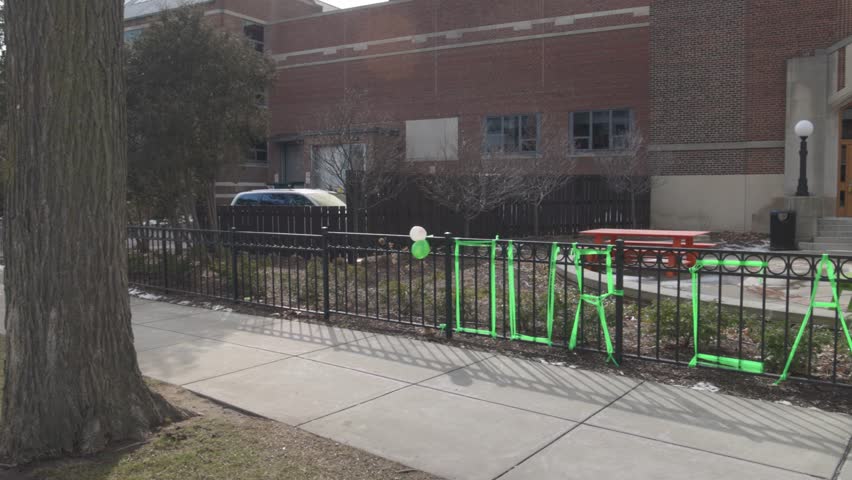 Union building on the campus of Michigan State University, site of a mass shooting in 2023 with flower memorial panning left to right.