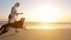 4k video footage of a woman going for a run with her dog on the beach at sunset